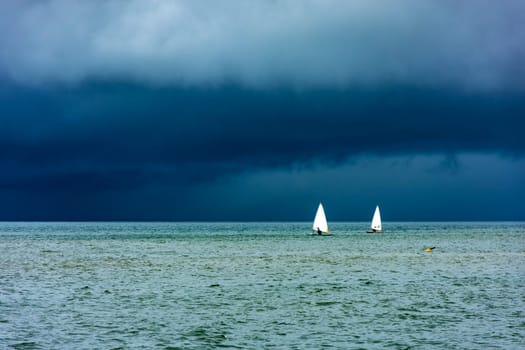 Sailboats sailing the waters of the sea of ​​Ilhabela island before the storm