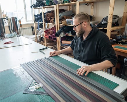 Leatherworker making leather belts in workshop