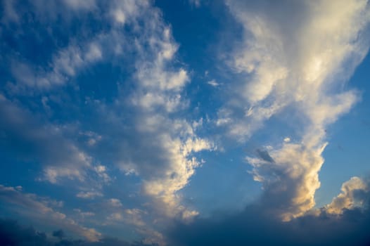 A view of pink clouds against a blue sky at sunset - stock photo