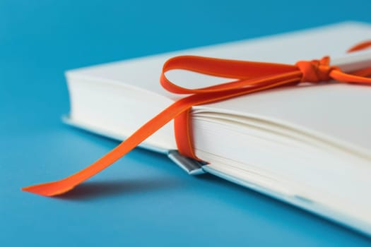 Travel journal with orange ribbon on blue background for creative writing and inspiration