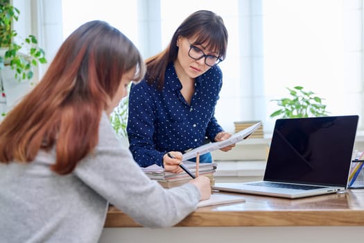 Female teacher mentor teaching young teenage girl student using laptop computer. Education, adolescence, learning, technology, teaching concept