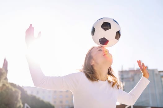 young caucasian woman head touching a soccer ball, concept of sport and football lifestyle
