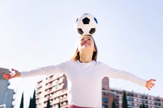 smiling caucasian woman head touching a soccer ball, concept of sport and football lifestyle