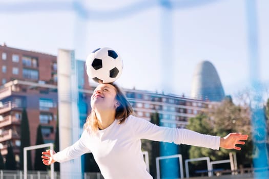smiling caucasian woman head touching a soccer ball, concept of sport and football lifestyle