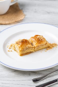 Traditional Turkish dessert walnut baklava on a white porcelain plate