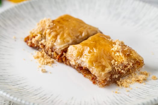 Traditional Turkish dessert walnut baklava on a white porcelain plate