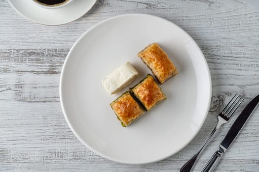 Traditional Turkish dessert pistachio baklava on a white porcelain plate