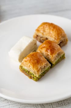 Traditional Turkish dessert pistachio baklava on a white porcelain plate