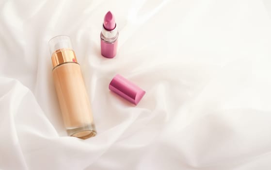 Cosmetic branding, glamour and skincare concept - Beige tonal cream bottle make-up fluid foundation base and pink lipstick on silk background, cosmetics products as luxury beauty brand holiday design
