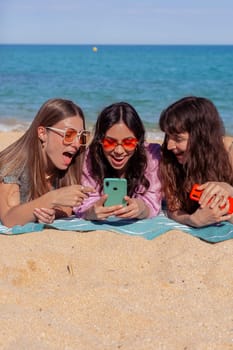 Group of smiling multiethnic women enjoying vacation. Beautiful and cheerful Gen Z girls with their mobile phones pose looking at the camera with a mobile phone.