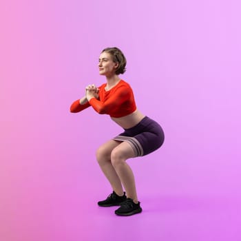 Full body length gaiety shot athletic and sporty young woman with fitness elastic resistance band in squat exercise posture on isolated background. Healthy active and body care lifestyle.