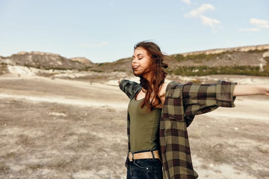 Joyful woman embracing nature's beauty in a vast field under the open sky