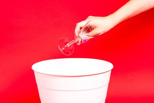 A woman throws a broken glass bowl into glass collection bin, waste sorting