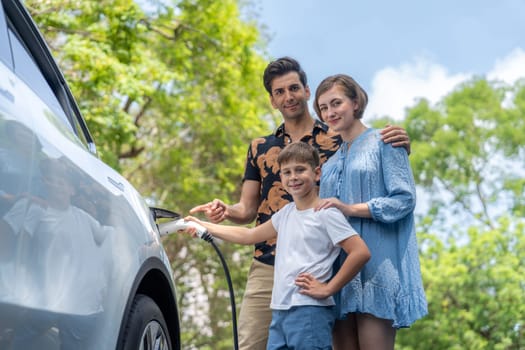 Family road trip vacation with electric vehicle, lovely family recharge EV car with green and clean energy. Natural and eco friendly car travel for sustainable environment. Perpetual