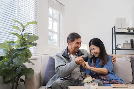 Elderly couple relaxing in a modern living room, enjoying quality time together, smiling and happy in a cozy home environment.