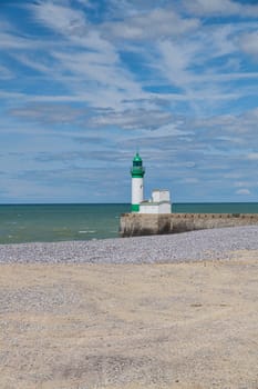 Le Treport lighthouse Seine Maritime, Normandy, France with the beach as foreground and blue sky with clouds as background
