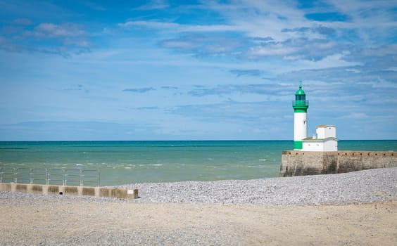 Le Treport lighthouse Seine Maritime, Normandy, France with the beach as foreground and blue sky with clouds as background