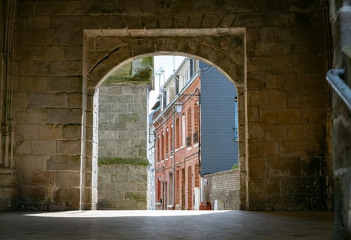 a view through an old church wall in a street in le treport in normandy in france