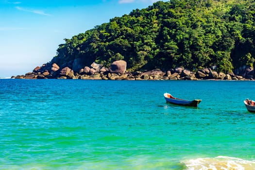 Rustic wooden fishing canoes on the sea waters of Ilhabela Island on the northern coast of Sao Paulo