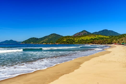 Tropical Castelhanos beach in Ilhabela surrounded by forest and sea