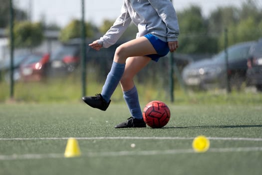 Girl Skillfully Dribbles Ball Between Flip Cups During Football Practice, Close-Up Shot