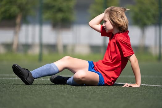 Girl In Football Uniform Sits At Match On Football Field