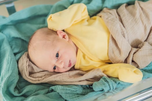 A newborn rests peacefully in his transparent bassinet in the hospital. The clear bassinet provides visibility for medical staff to monitor the baby's well-being while ensuring a safe and comfortable environment for the newborn.