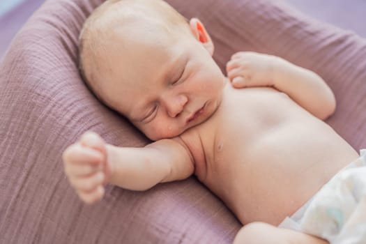 The baby is sleeping peacefully in his cozy nest. Newborn photo session captures the serene innocence and warmth of early moments.