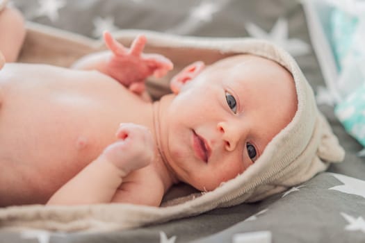 Baby after shower wrapped in a towel. This adorable moment captures the freshness and comfort of a clean baby, highlighting the tender care and love in the daily routine.