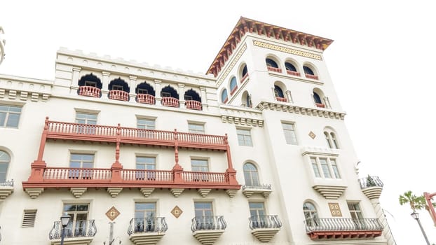 The imposing structure stands tall, its elegant balconies and arched windows reflecting the suns rays. A captivating blend of history and modern luxury awaits within these walls.