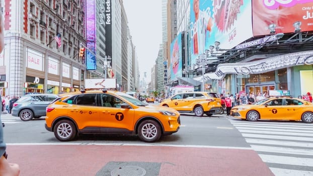 In the lively city that never sleeps, yellow taxis wait in Times Square, surrounded by bright lights and urban energy, ready to transport passengers through the bustling streets.