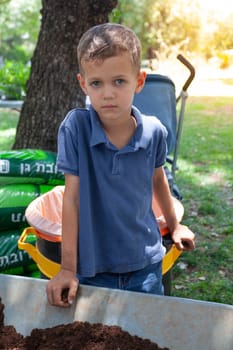 Farmer boy at a cart with earth. High quality photo