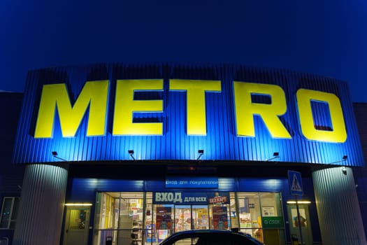 Tyumen, Russia-March 02, 2024: Metro logo close up Sign Against City Skyline