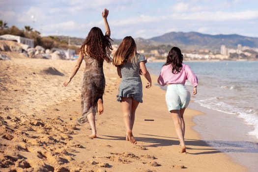 Cheerful multiethnic friends with sunglasses happy on vacation on the beach, looking at the camera.