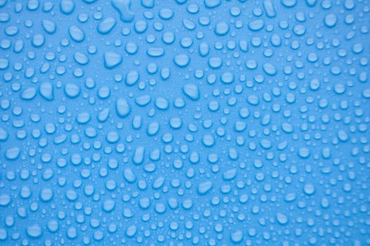 Close up of rain water droplets on blue cover background
