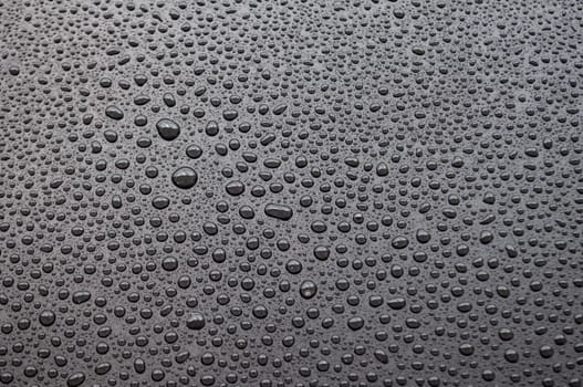 Top view of rain water drop on dark background.