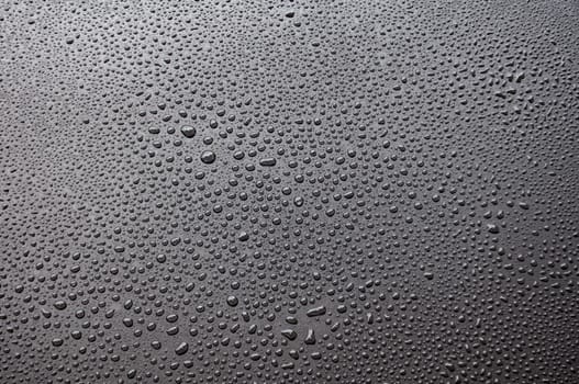 Close up of water droplets on black cover background.