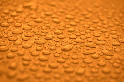 Close up of rain water droplets on golden cover background