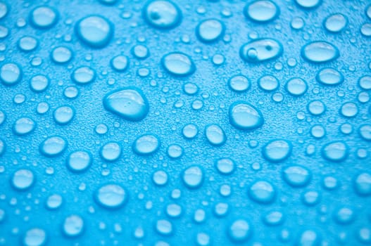 Close up of water droplets on blue cover background