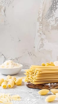 Pasta recipe preparation flatlay background with ingredients, spaghetti, olive oil, garlic, tomatoes and spices in the kitchen, homemade food recipe idea