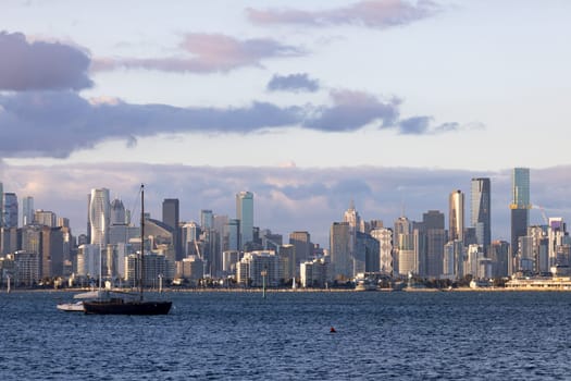 Melbourne skyline across Hobsons Bay from Ferguson St Pier in Williamstown waterfront at dusk in winter in Victoria, Australia