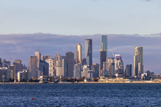 Melbourne skyline across Hobsons Bay from Ferguson St Pier in Williamstown waterfront at dusk in winter in Victoria, Australia