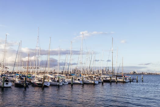 Melbourne skyline across Hobsons Bay from Ferguson St Pier in Williamstown waterfront at dusk in winter in Victoria, Australia
