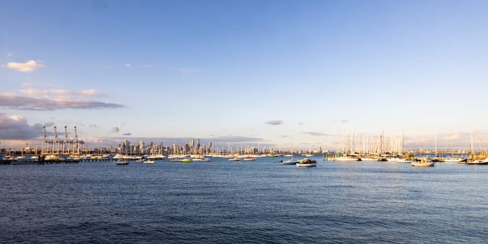 Melbourne skyline across Hobsons Bay from Ferguson St Pier in Williamstown waterfront at dusk in winter in Victoria, Australia