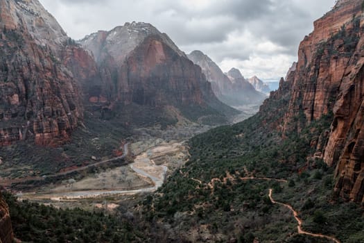 View of the amazing canyon in Zion National Park from the West Rim Trail on a stormy day with rain. Rugged cliffs, scenic hiking path, and dramatic weather create a captivating scene - Utah, USA