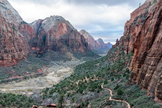 Majestic view of the canyon from the West Rim Trail in Zion National Park, Utah. Epic rock formations and expansive landscape with the trail winding below. Taken on a cloudy day in winter - USA