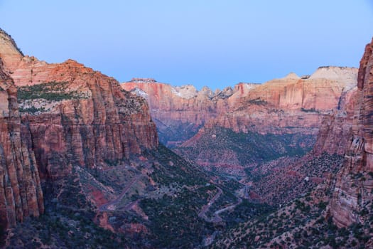 Breathtaking sunrise view of Zion Canyon in Utah, showcasing rugged cliffs, winding road, and the vast natural beauty of the National Park. Perfect for nature, travel, and adventure - USA