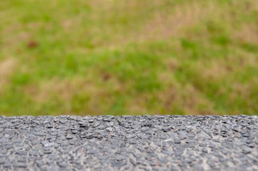 Marble table top with grass background with customizable space for mock-up.