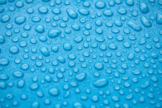 Close up of water droplets on blue cover background.