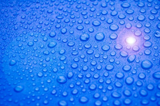 Water droplets with shining light on blue cover background. Water droplets concept